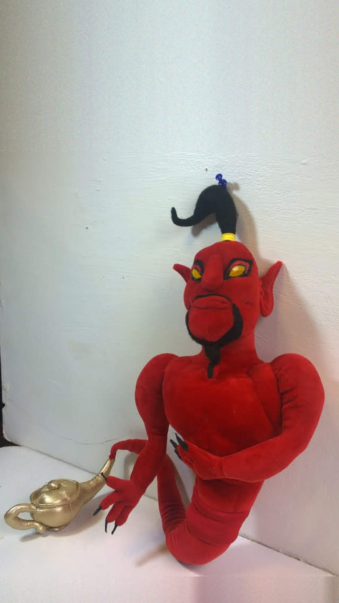 Red Jafar genie plush with yellow eyes and a black goatee, arms folded, lamp at his side, sewn to order