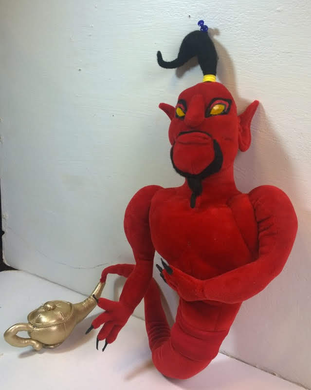 Red genie plush of Jafar with crossed arms Red genie plush of Jafar with arms crossed, pointed ears and black topknot, golden lamp beside him, handmade