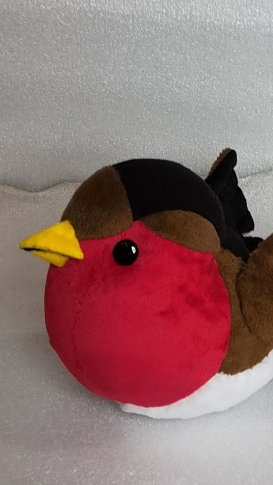 Round bullfinch plush with a black cap, red breast and yellow felt beak, sewn to order for Christmas