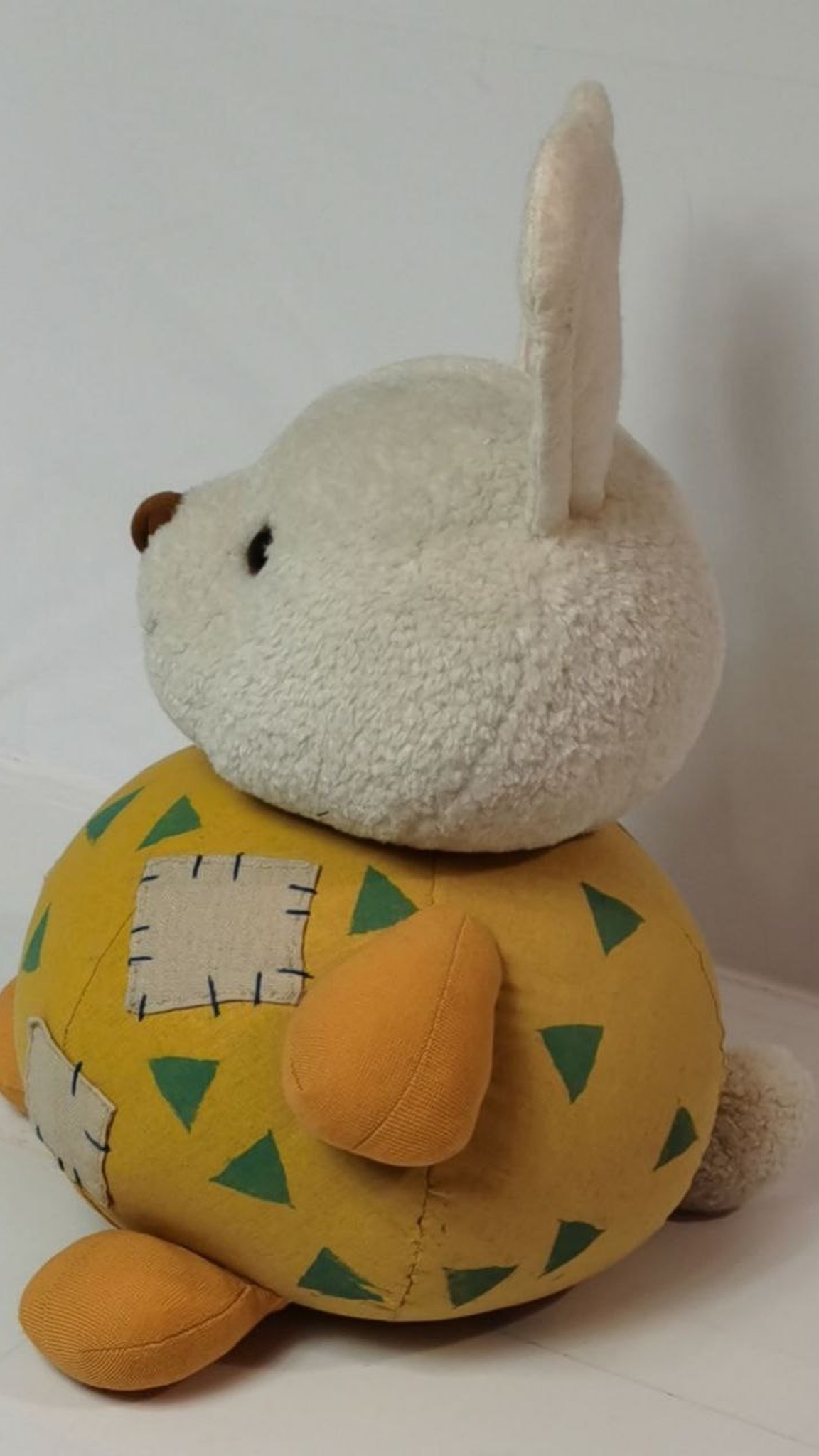 Round bunny plush with a fluffy cream head, a little white tail and teal triangles, handmade from an AI picture