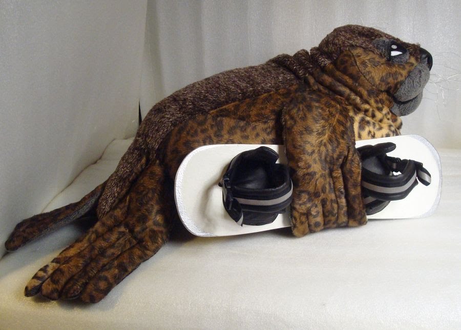 Custom seal stuffed animal hugging a snowboard Custom seal stuffed animal hugging a white snowboard, sewn to order with spotted faux fur flippers and tail