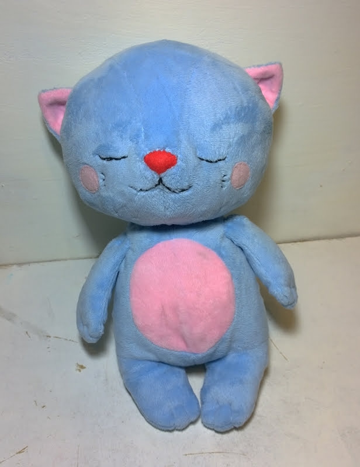 Blue sleepy cat plush with closed eyes Blue sleepy cat plush with embroidered closed eyes, red nose and pink cheeks, custom made by hand