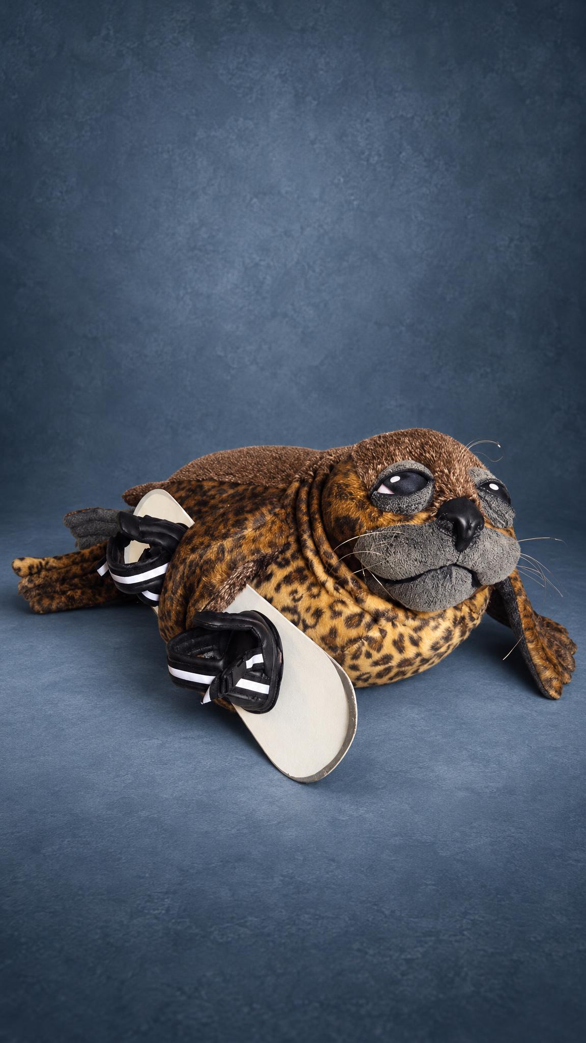 Snowboarder seal plush handmade to order: spotted faux fur seal with big dark eyes holding a white board