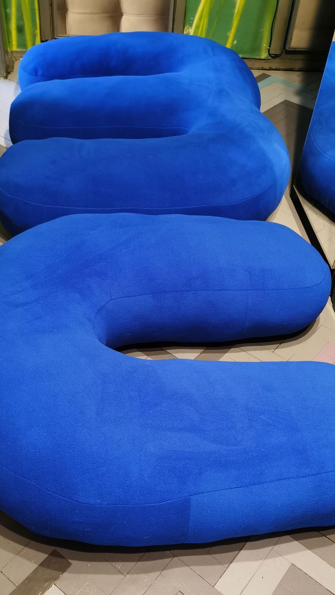 Soft logo letters in thick blue plush lying on the floor, custom brand decor made to order