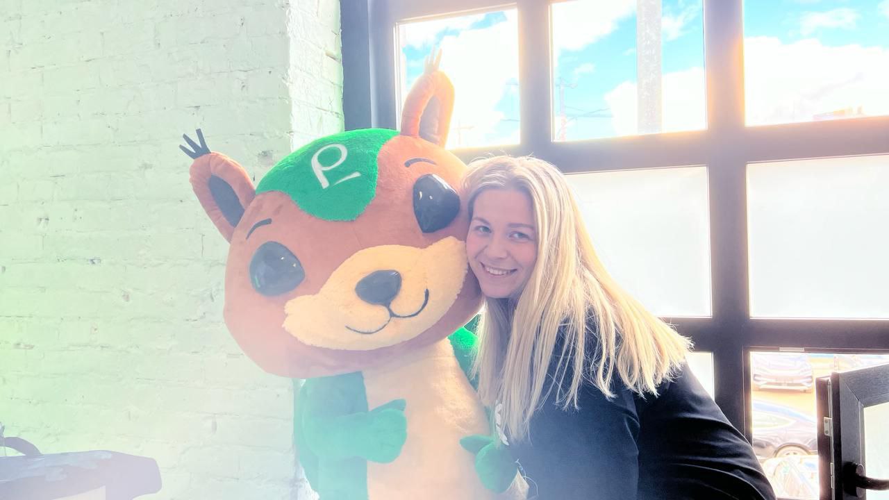 Hugging the squirrel mascot Woman hugging a big squirrel mascot plush at a trade show, a custom company mascot sewn to order