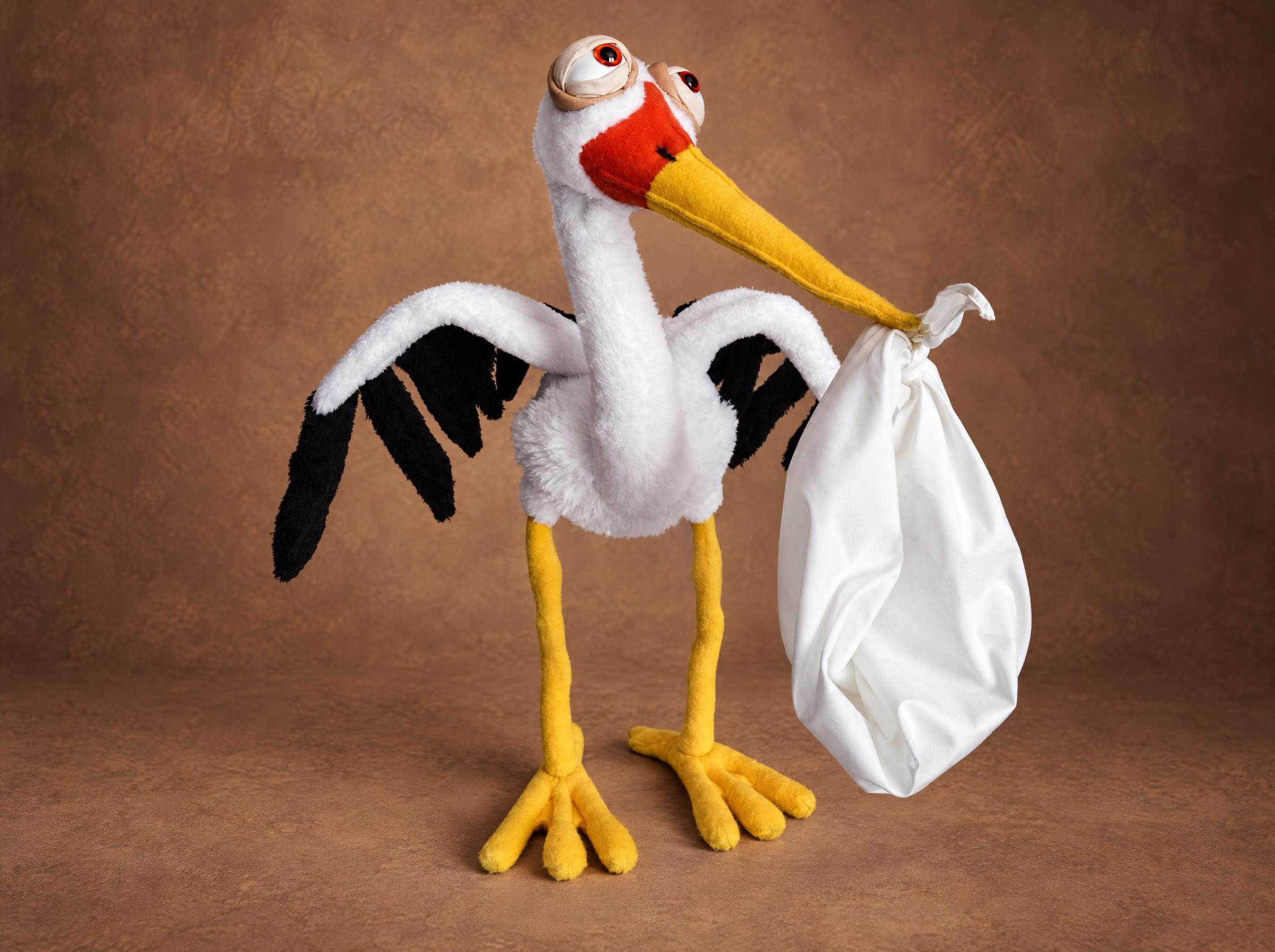 Stork plush with a baby bundle Stork plush carrying a white baby bundle in its yellow beak, black wing tips, long yellow legs, made to order