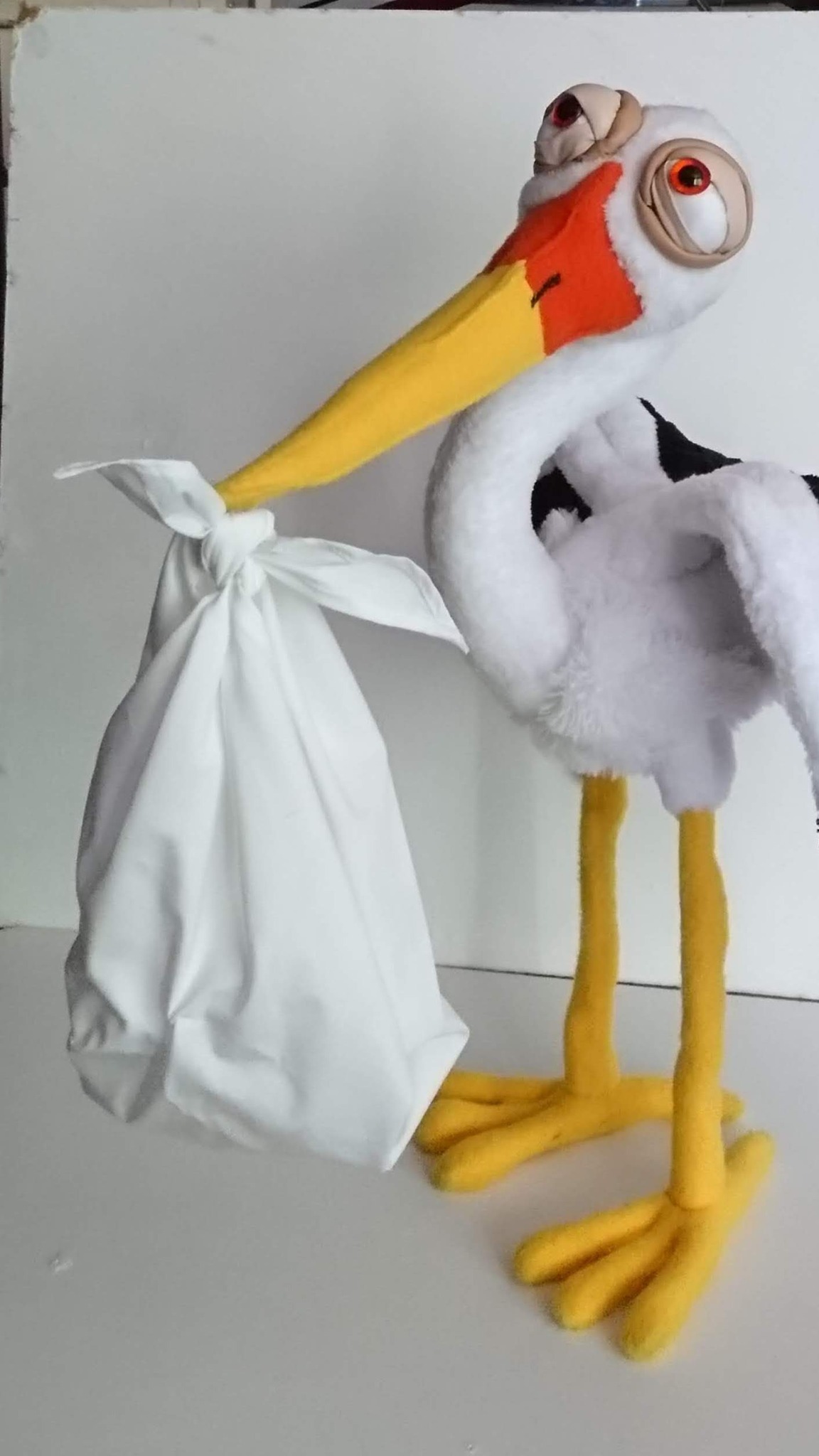 Stork stuffed animal delivering a knotted white baby bundle, with webbed yellow feet, made to order