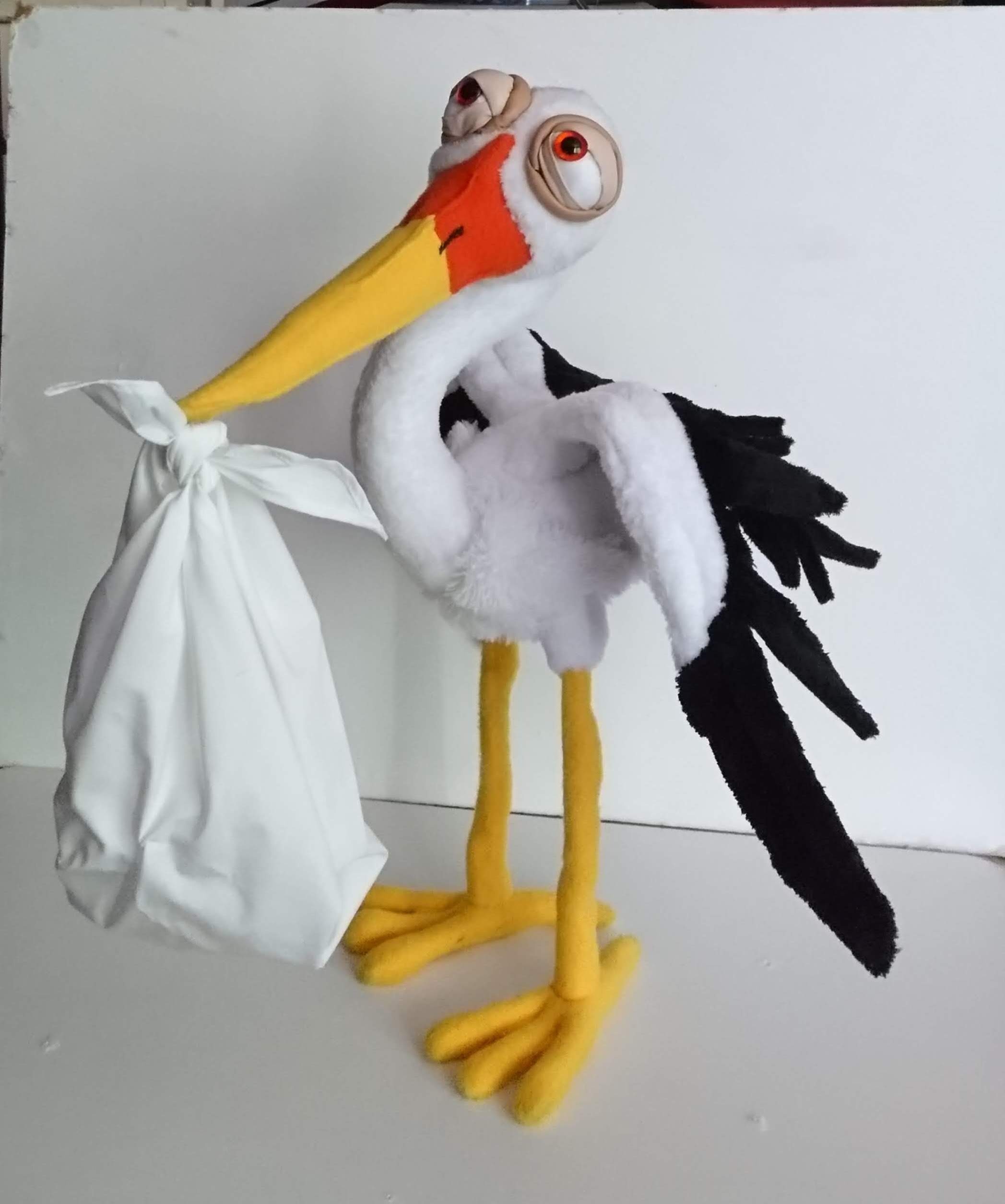 Stork stuffed animal with a baby bundle Stork stuffed animal delivering a knotted white baby bundle, with webbed yellow feet, made to order
