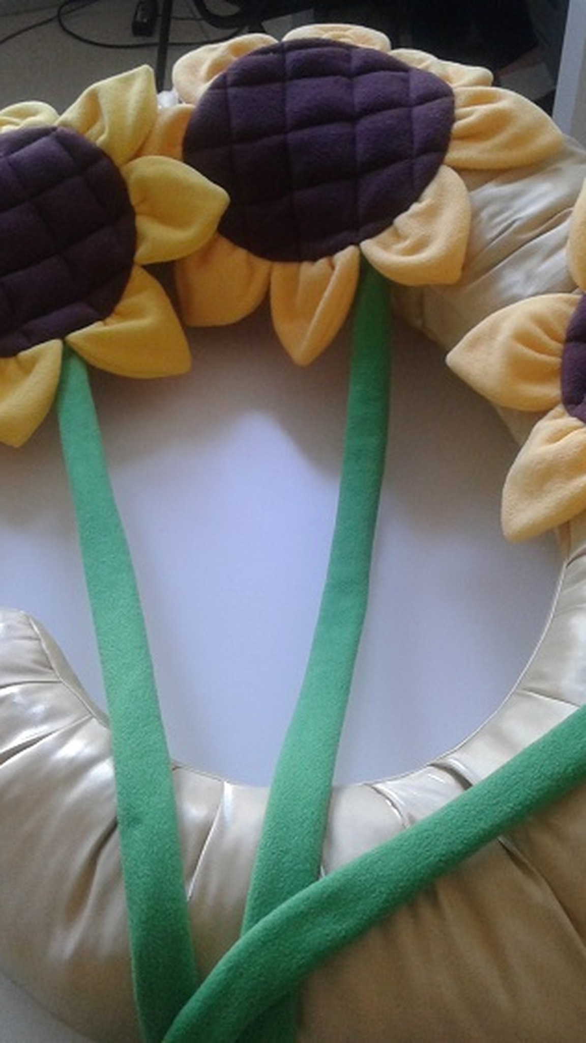 Three sunflower cushions with quilted brown centers lying on a gold moon photo prop, sewn to order