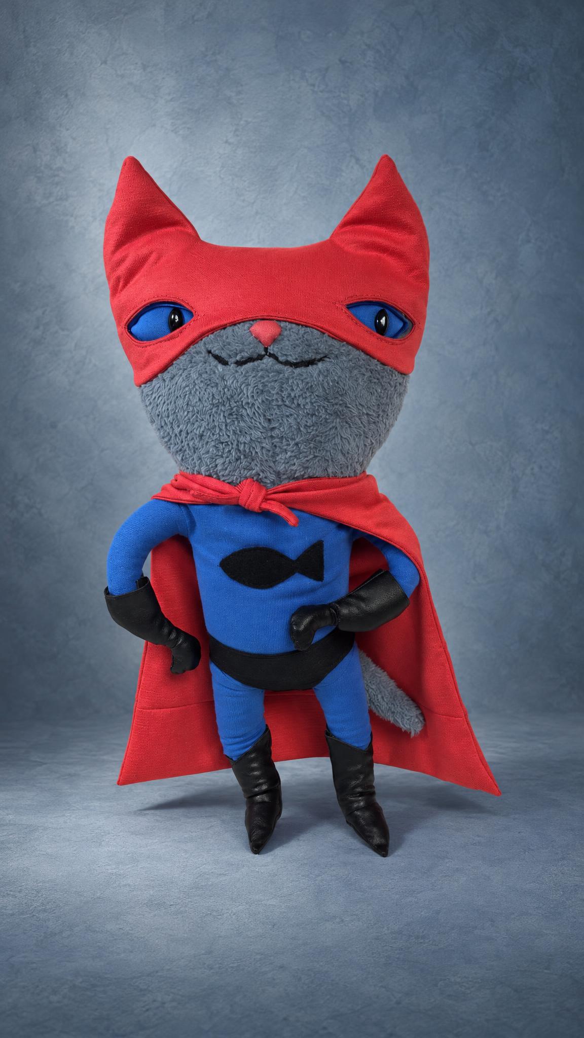 Custom superhero cat plush with hands on hips, red cape and fish emblem on a blue suit, sewn by hand to order