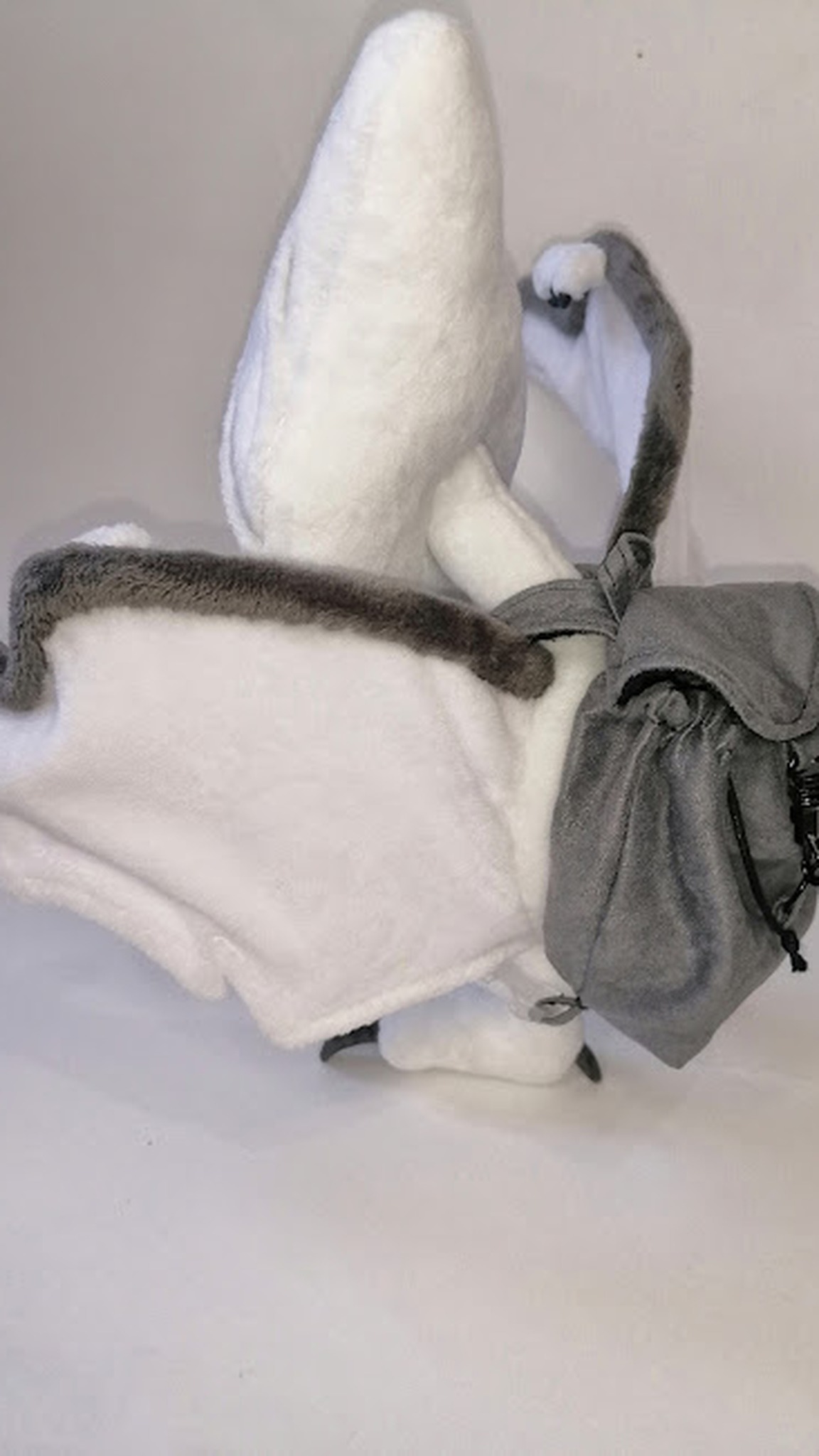 White tamagotchi pterodactyl plush with its grey clip-on backpack, sewn by hand to order