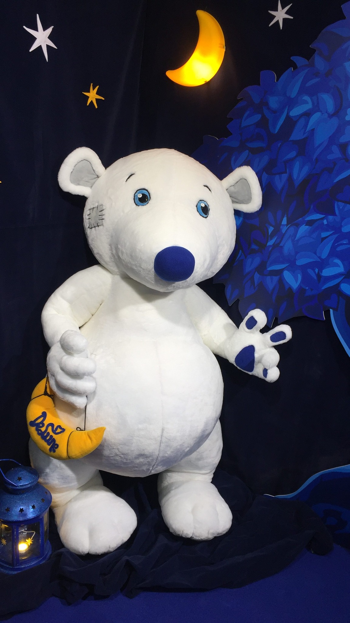 Giant teddy bear mascot at an exhibition stand with a night sky, stars and lanterns, custom made to order