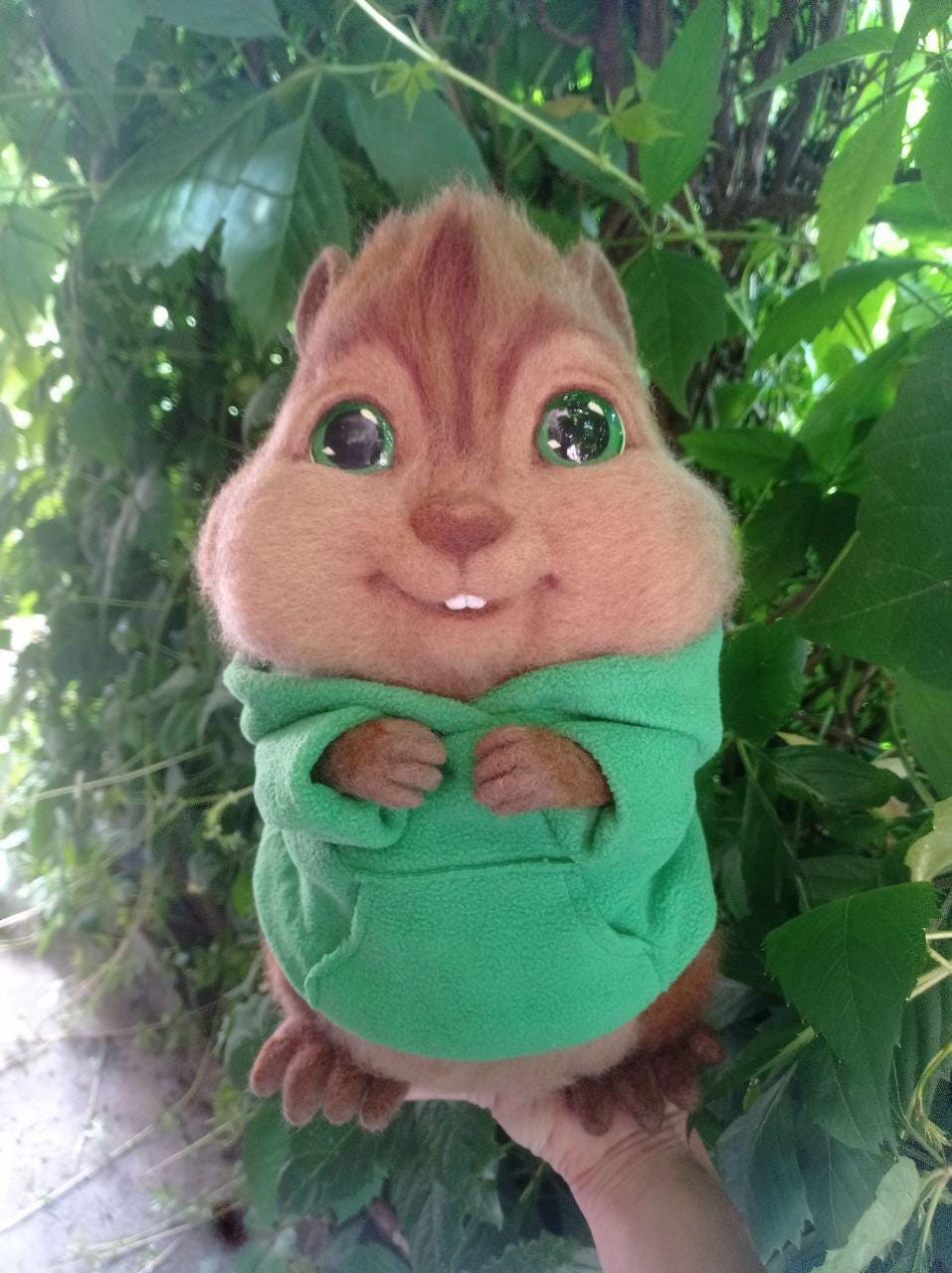 Theodore chipmunk plush outdoors Theodore chipmunk plush held in a hand outdoors, green hoodie and wool fur, Alvin and the Chipmunks fan toy