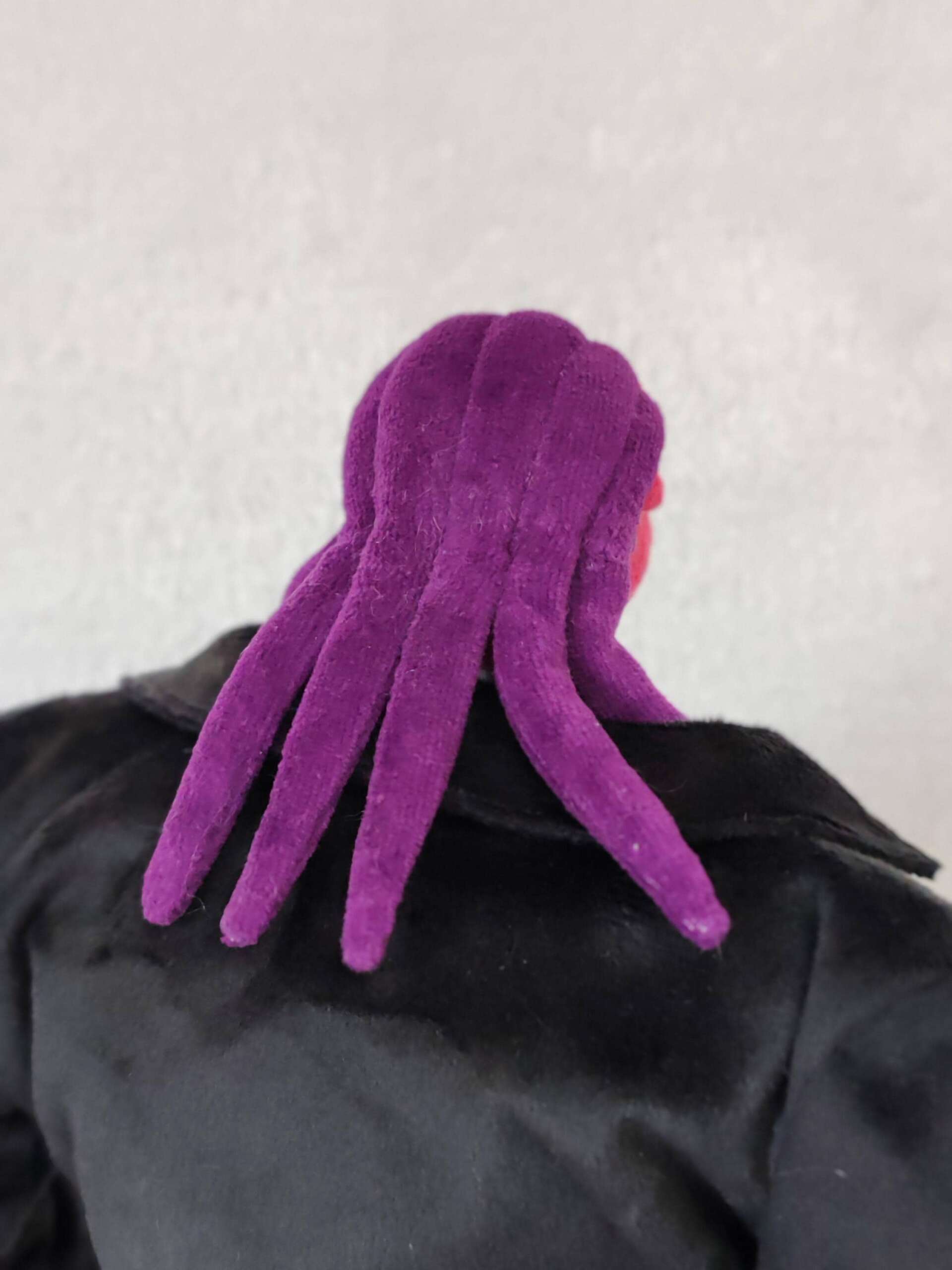 Thrax plush with purple tendrils Purple tendrils hanging down the back of a handmade Thrax plush in a black coat, Osmosis Jones toy to order