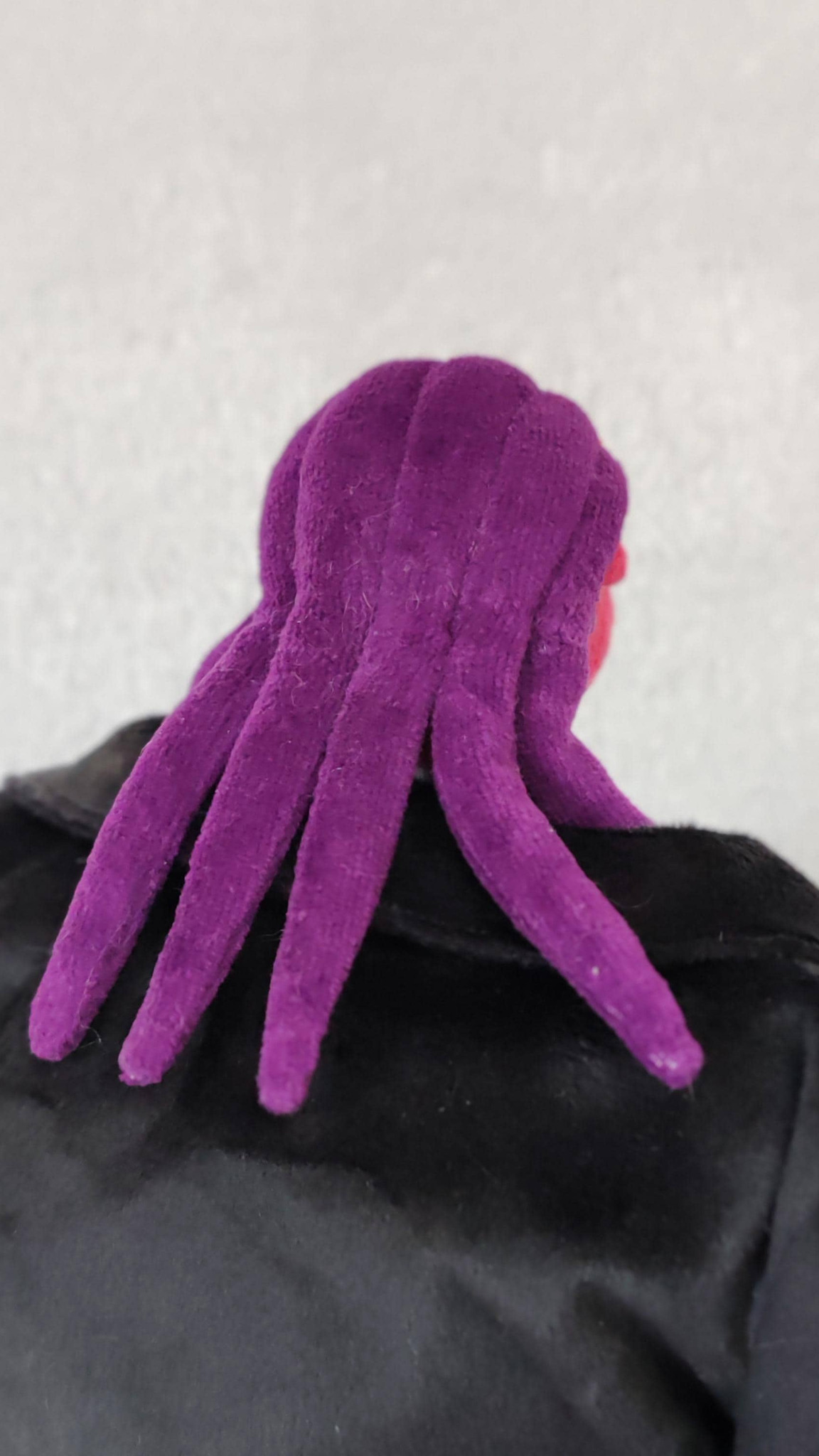 Purple tendrils hanging down the back of a handmade Thrax plush in a black coat, Osmosis Jones toy to order