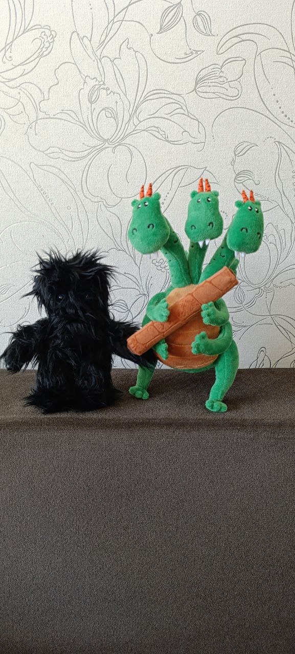 Three-headed dragon plush and a shaggy friend Handmade three-headed dragon plush holding a wafer roll next to a black shaggy plush, custom made to order