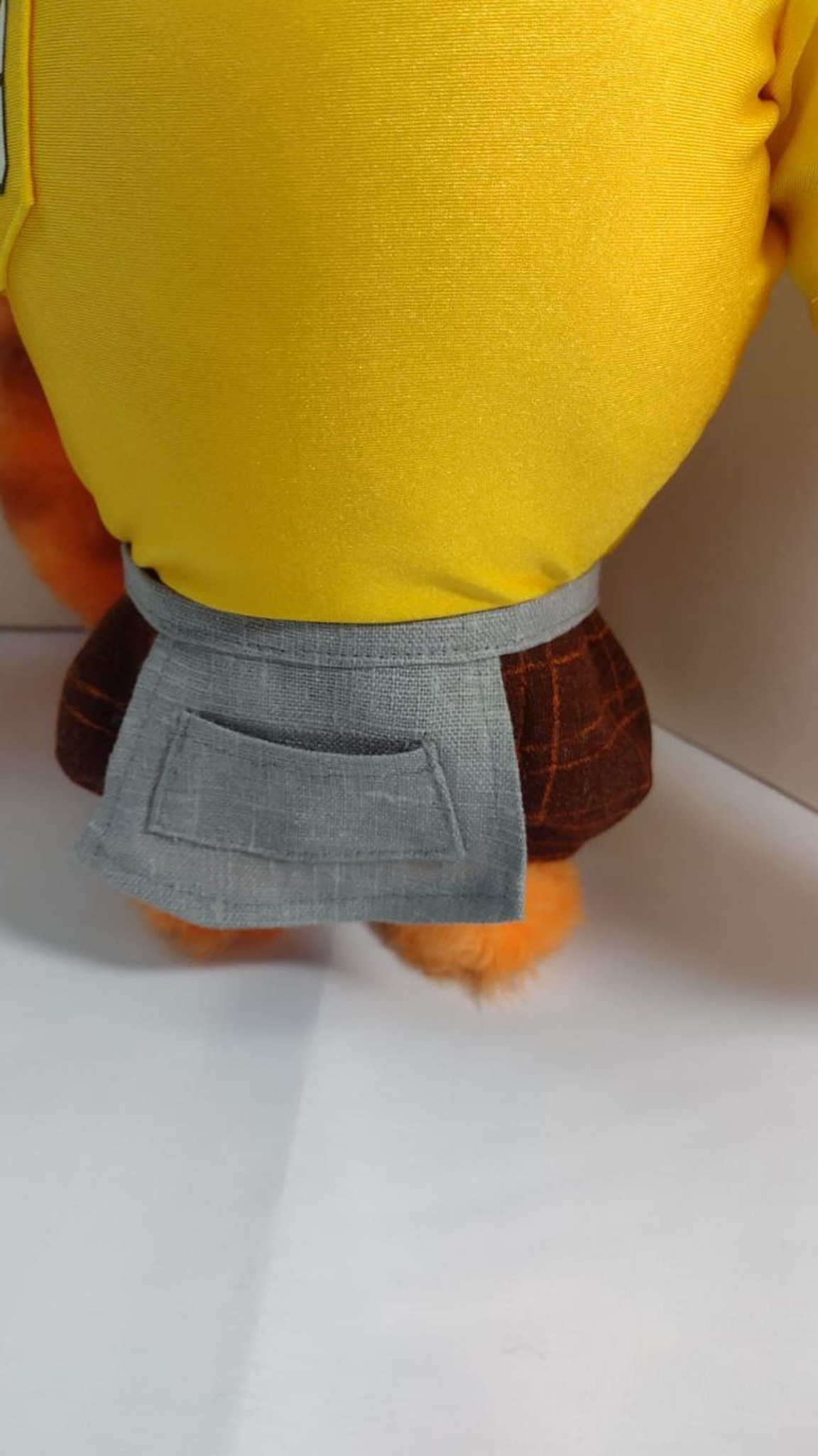 Tiger mascot plush grey apron with a pocket over brown plaid shorts and a yellow T-shirt, handmade to order