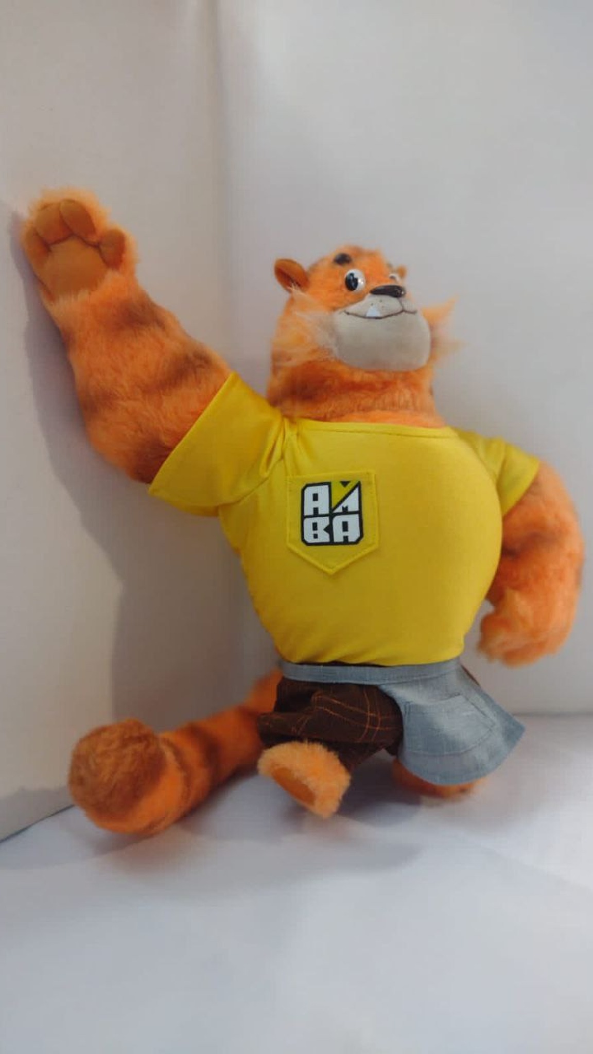 Custom tiger mascot plush waving a jointed paw, yellow T-shirt and grey apron, sewn by hand to order