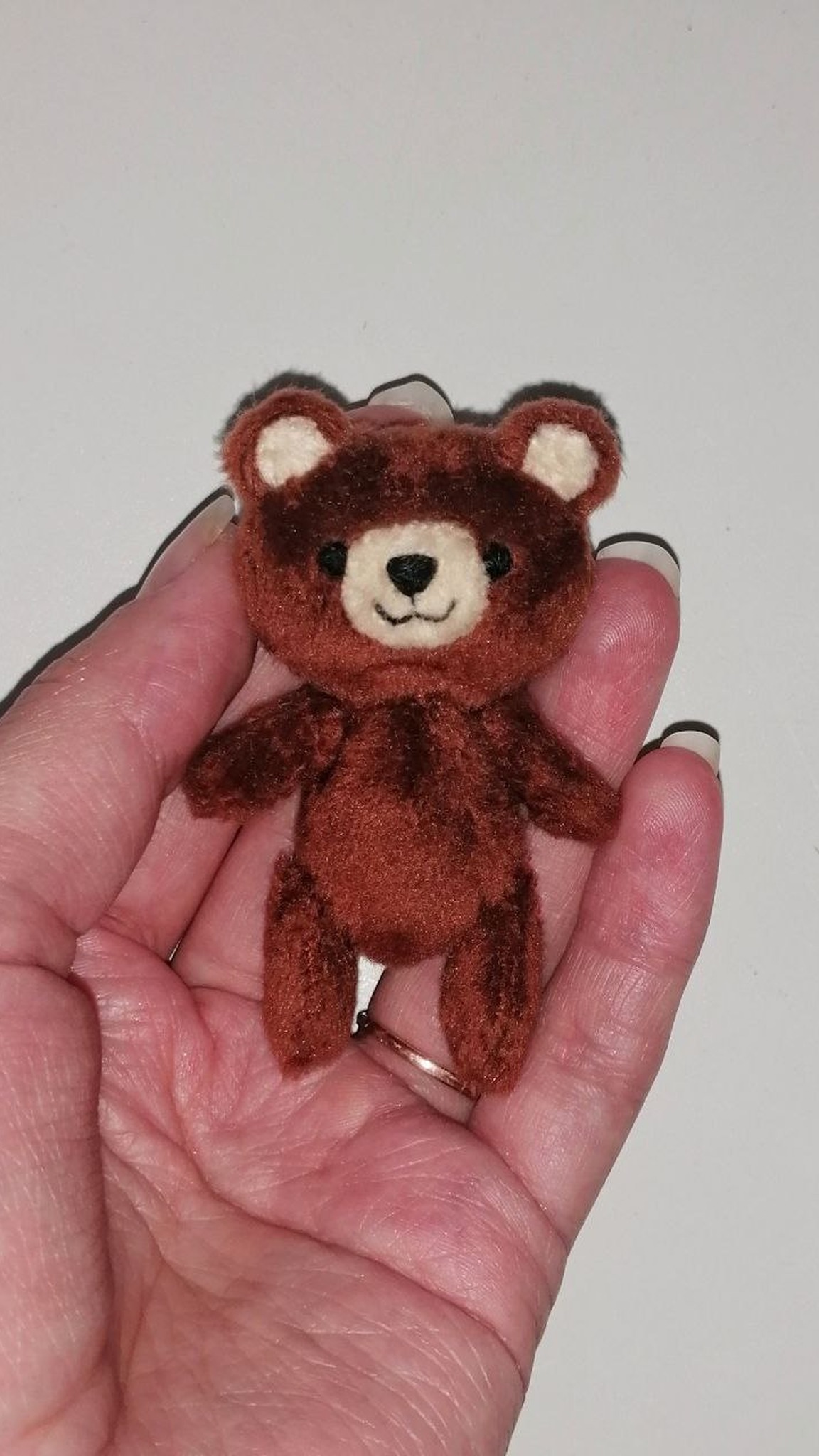 Palm-sized brown teddy bear with a cream muzzle, the accessory for a custom pink bunny sticker plush, handmade