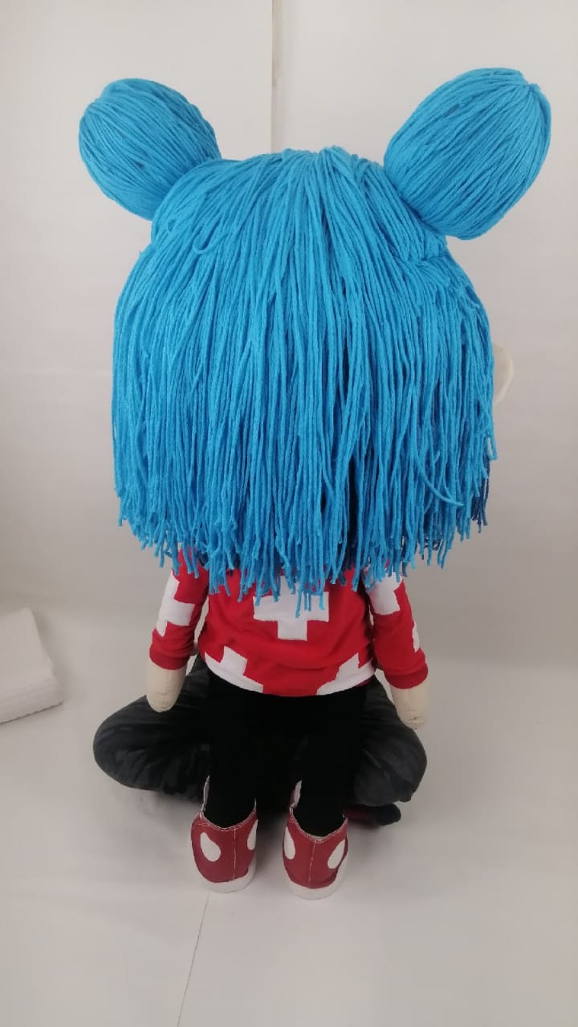 Turquoise yarn hair with two buns on a handmade Toca Boca doll in a red cross top, made to order