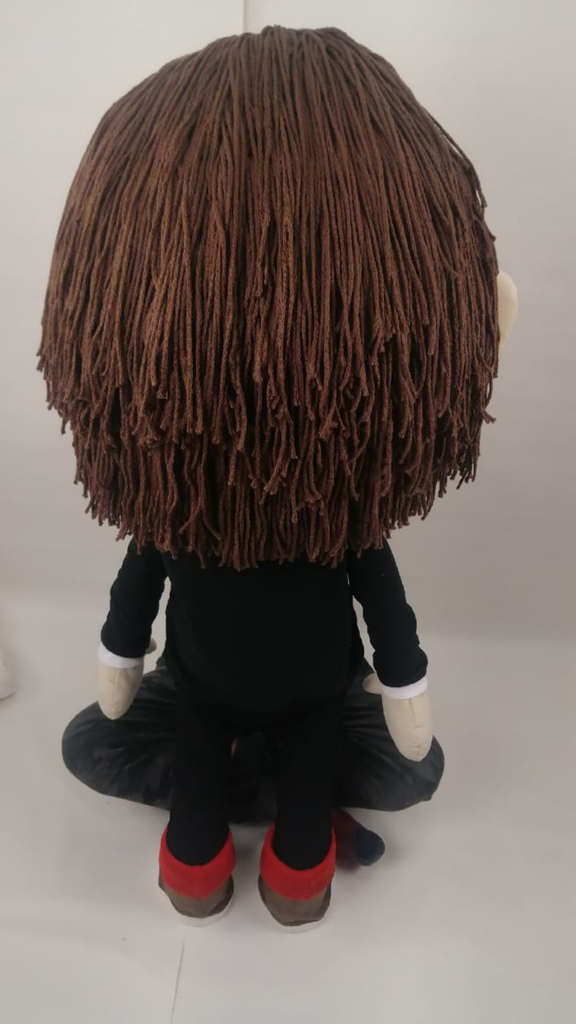 Long brown yarn hair on a custom Toca Boca doll in a black top and red socks, sewn to order