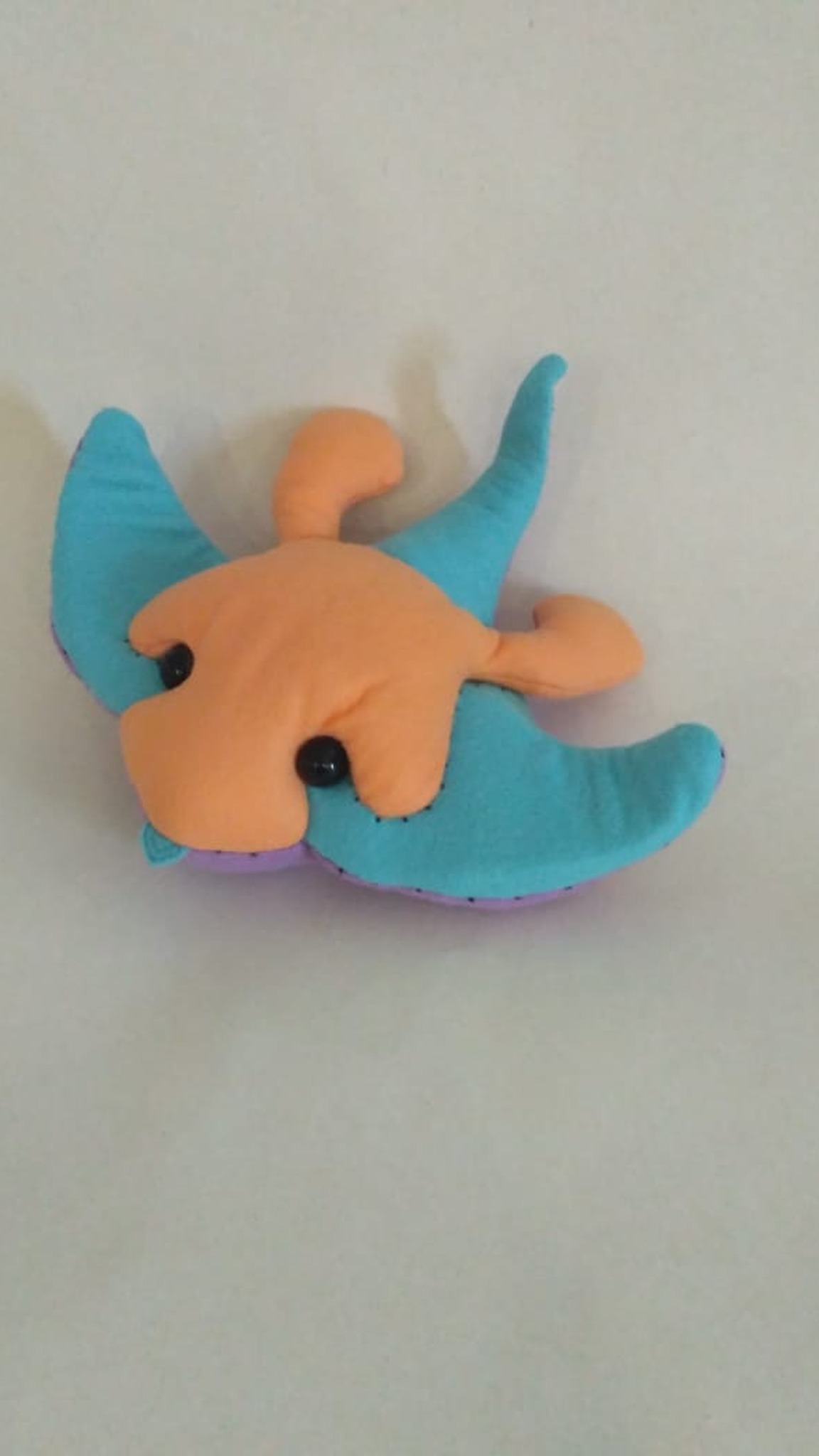 Turquoise stingray plush sewn to order from a game character, orange curled horns and a long curving tail