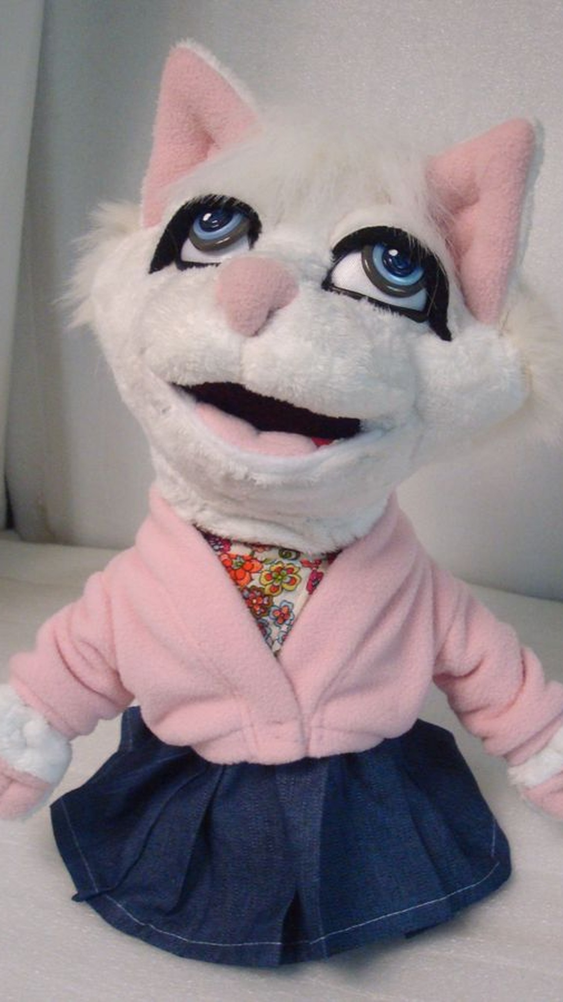 Blue-eyed white cat TV puppet in a pink cardigan and denim skirt, custom hand puppet made to order