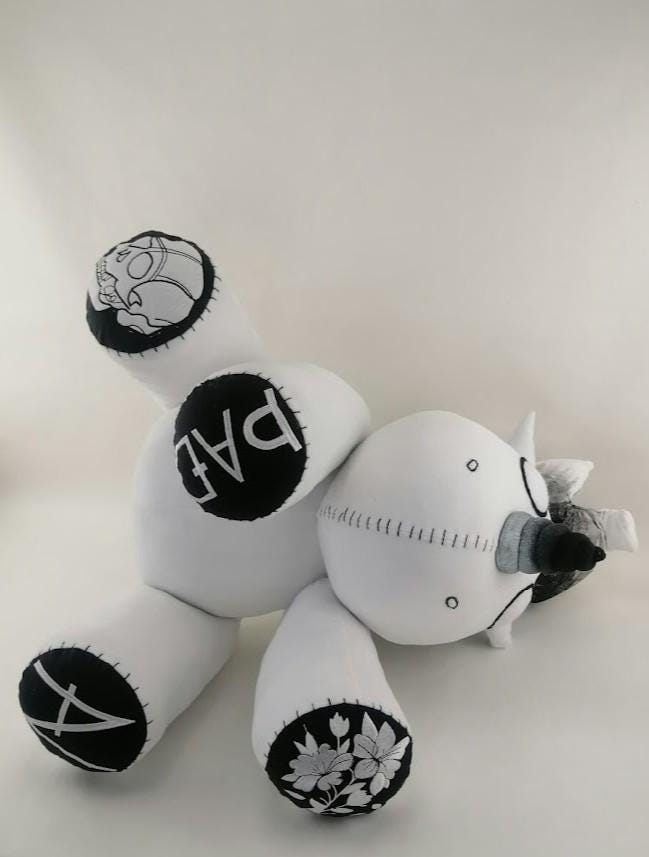 Voodoo unicorn plush foot pads Voodoo unicorn plush lying back to show black foot pads with a skull, lettering and flowers, sewn to order