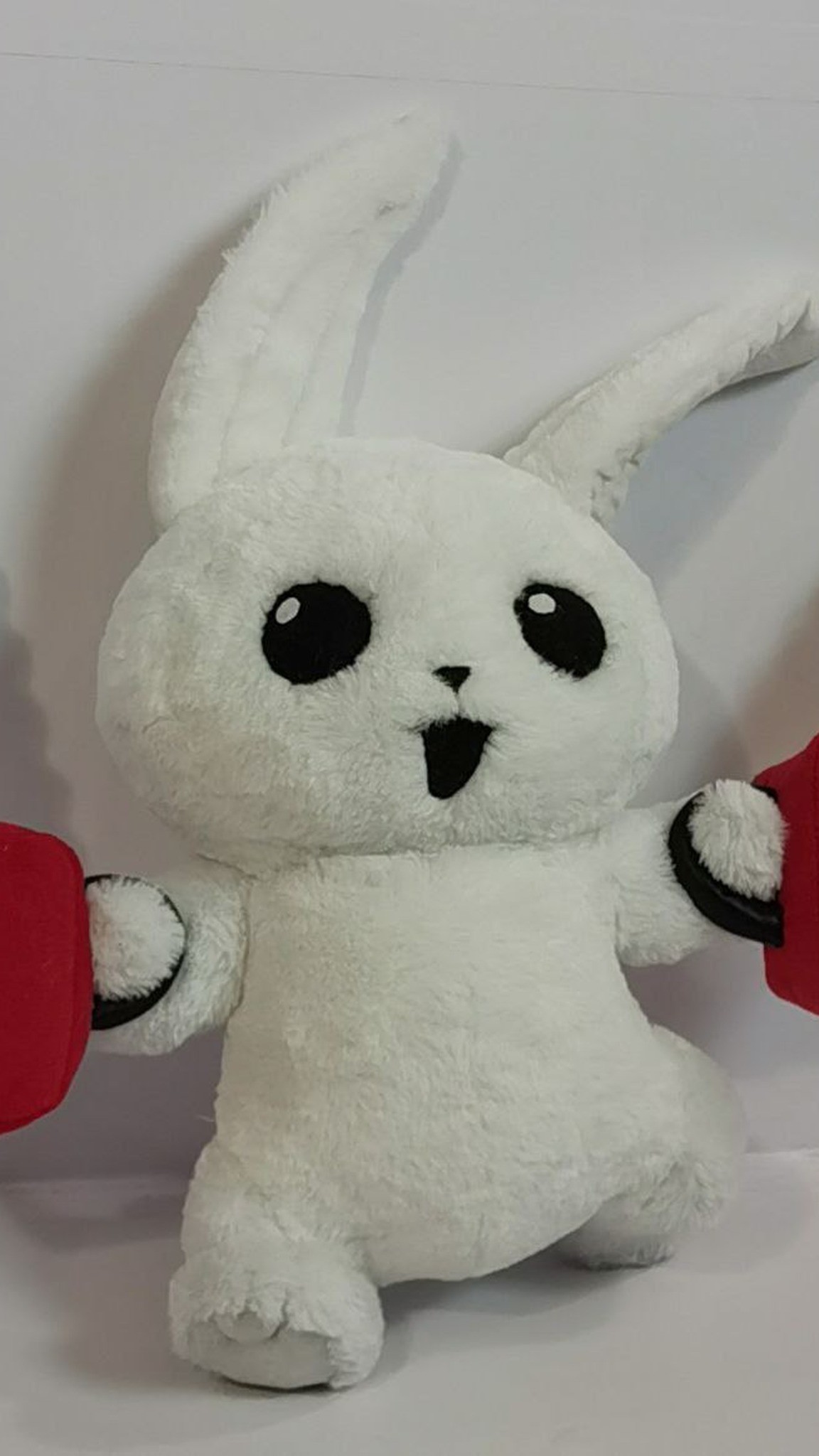 White bunny plush with round black eyes and an open grin, gripping red chainsaw handles, made to order
