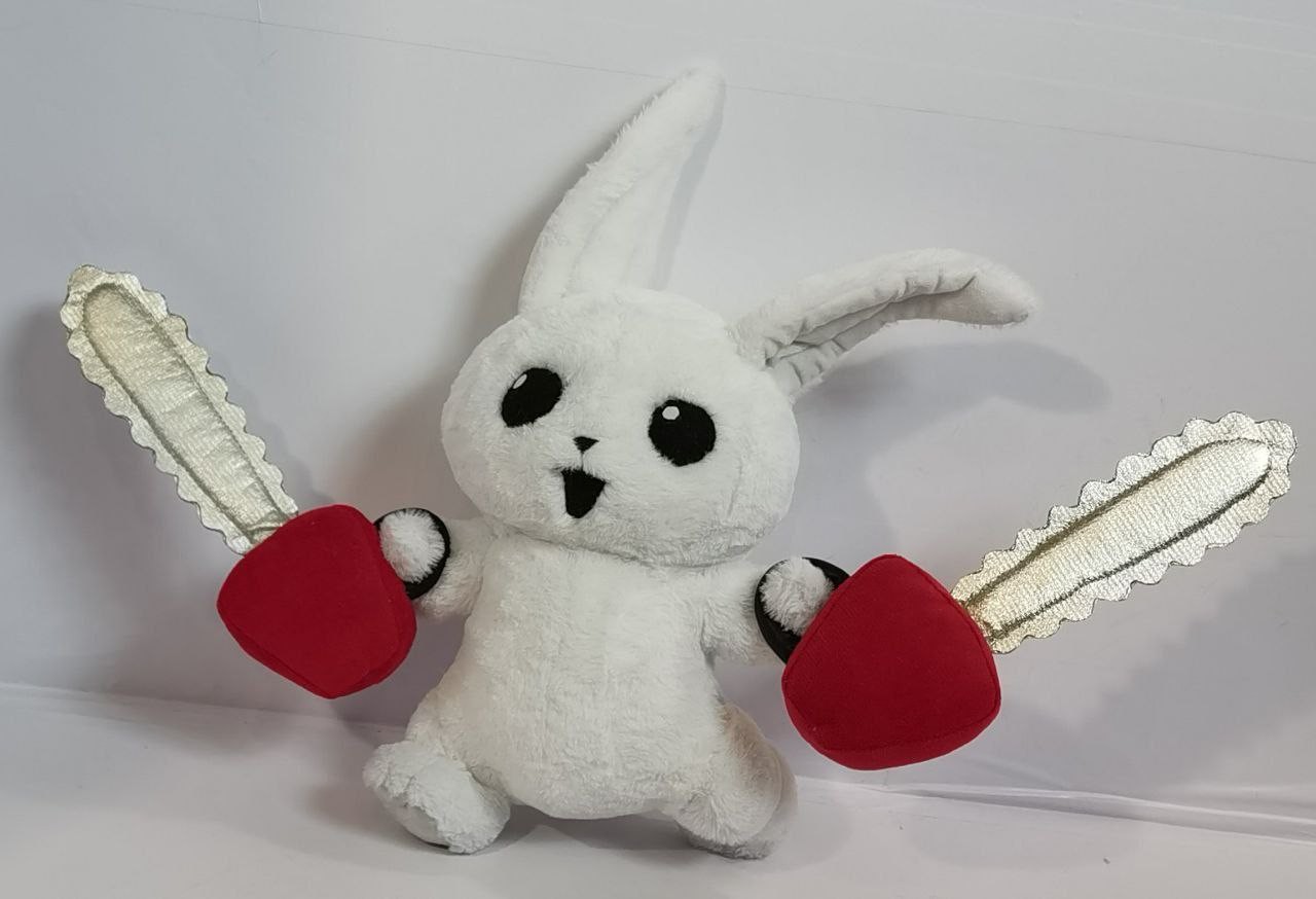 White bunny plush with two chainsaws White bunny plush with arms spread wide and a stuffed chainsaw in each paw, sewn to order from a sticker