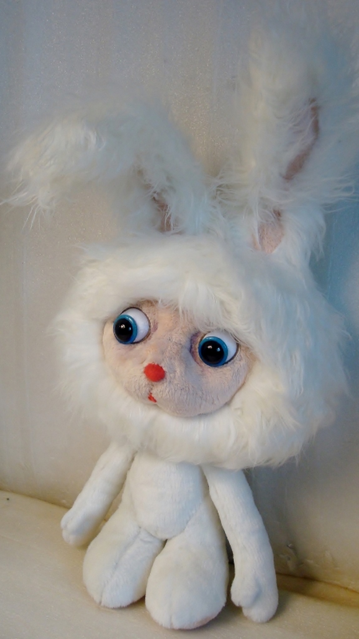 White cartoon bunny plush with blue eyes and long pink-lined ears, handmade to order from a cartoon
