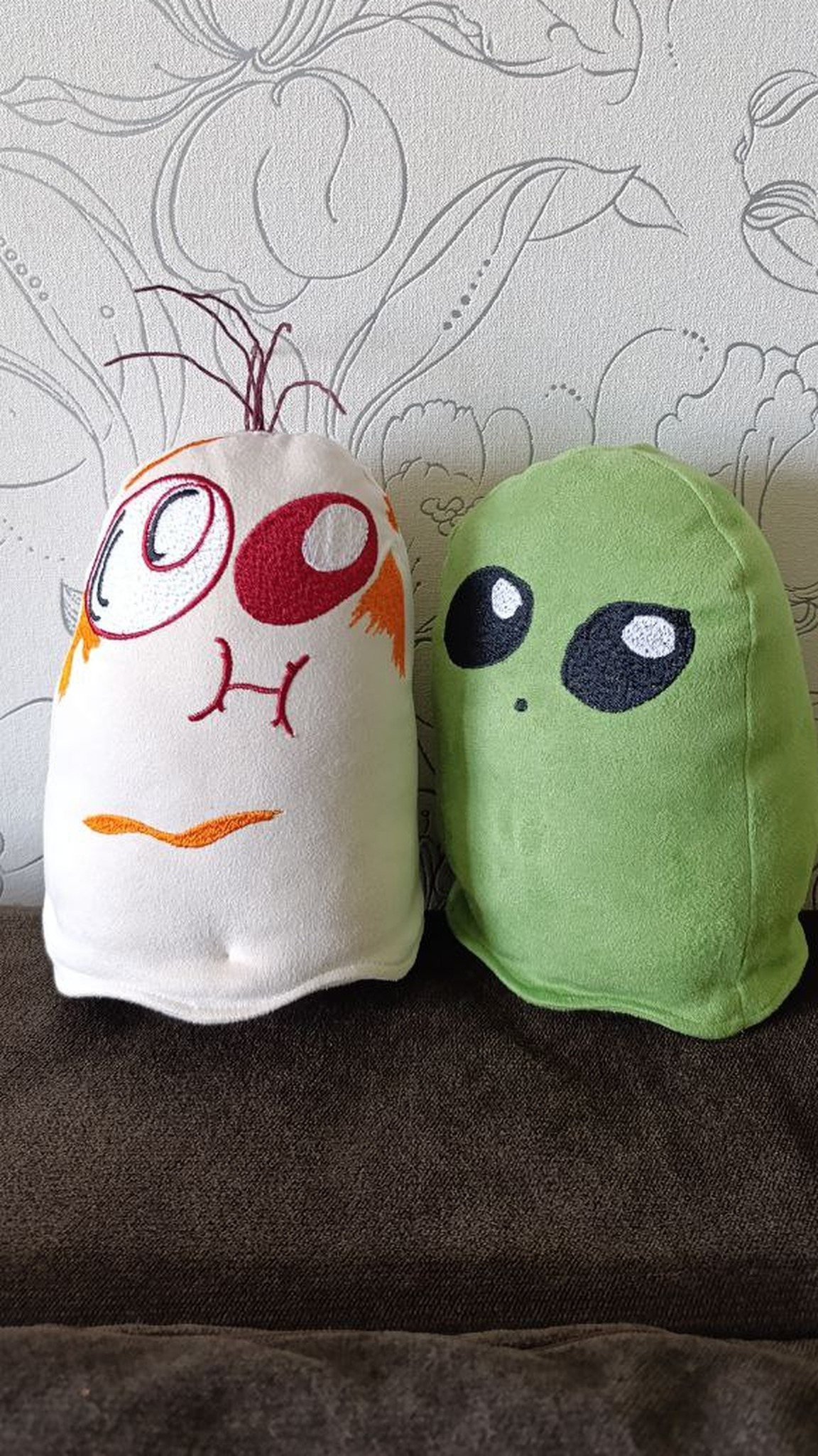 White ghost plush with one huge eye and a green alien-eyed ghost plush, handmade to order from a drawing