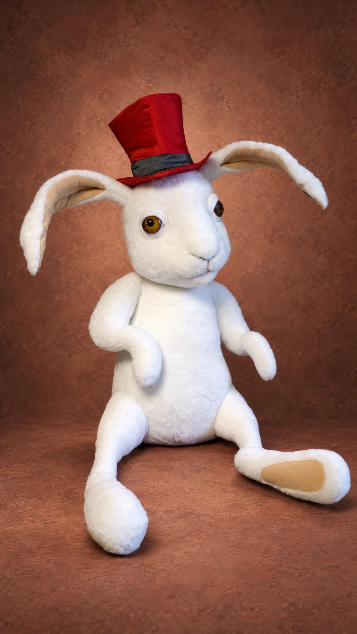 White rabbit stuffed animal sewn to order, sitting with long legs out, red top hat and tan foot pads