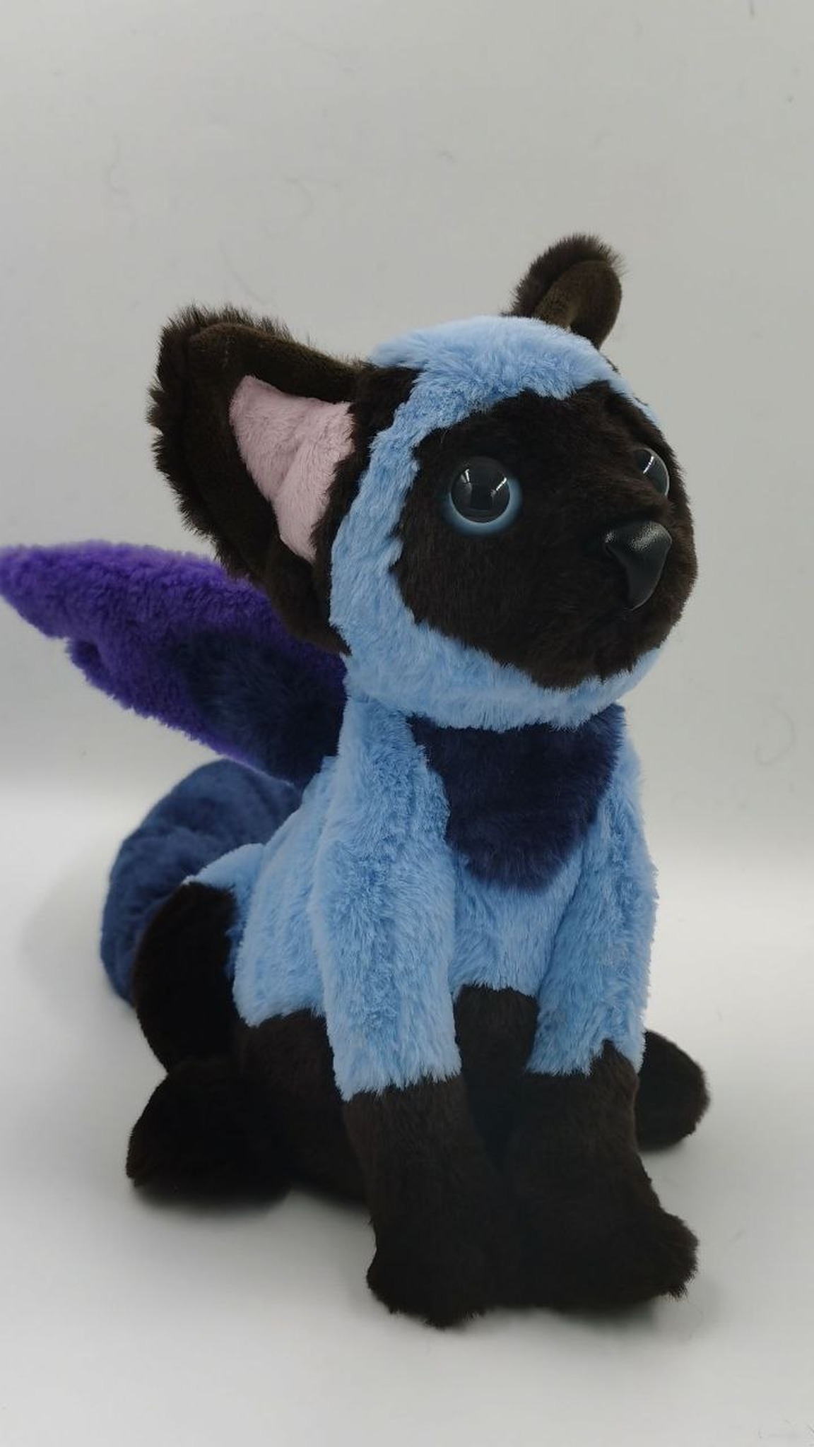 Blue winged cat plush with glossy blue eyes and purple wings, a custom OC plush handmade to order