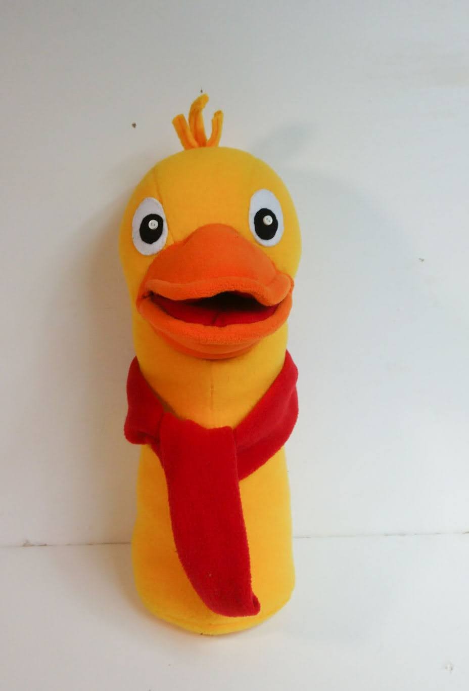 Yellow duck plush with a red scarf Yellow duck plush with an open orange bill, felt eyes, a yarn tuft and a red fleece scarf, made to order